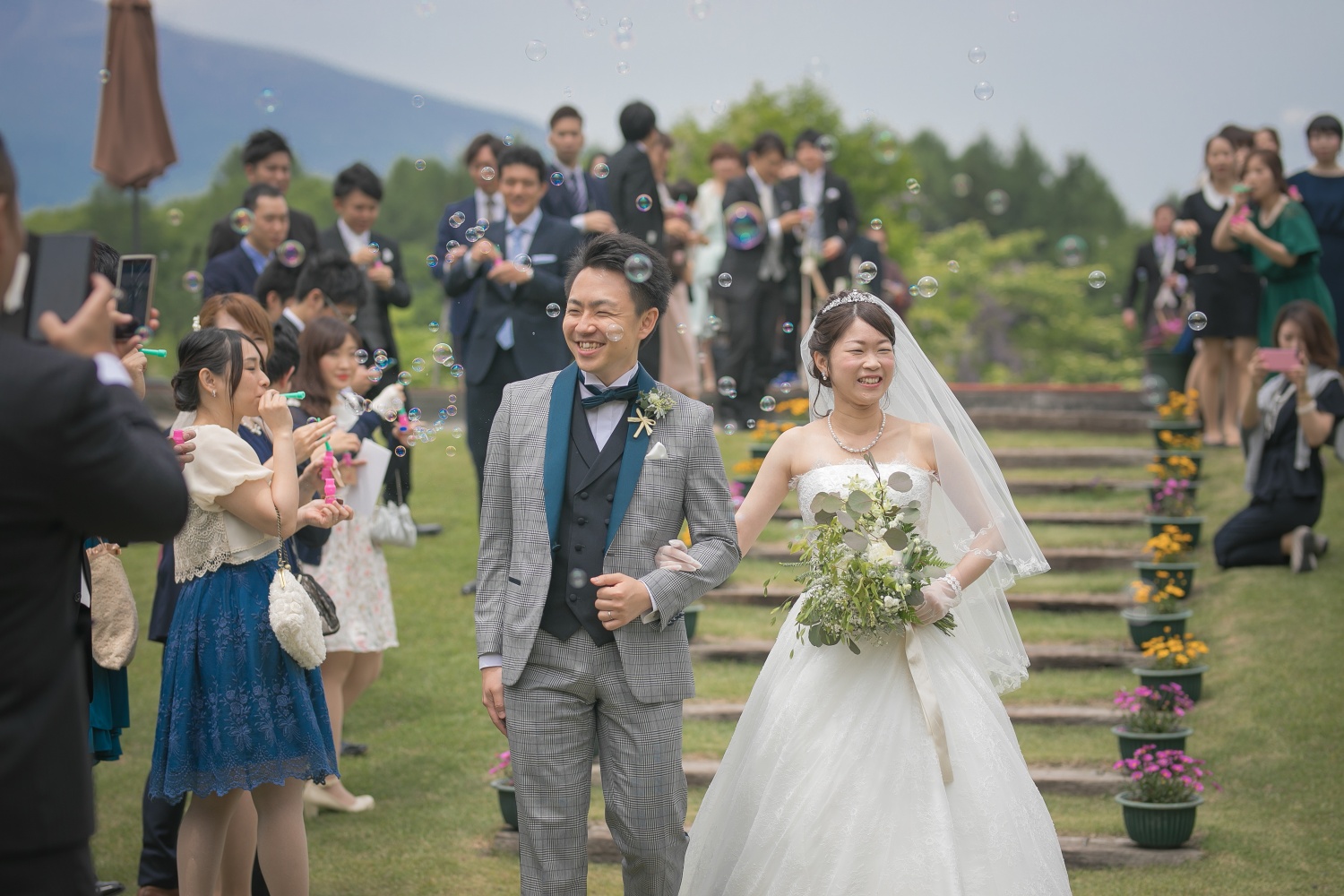 挙式後のシャボン玉シャワーで退場する新郎新婦の写真です